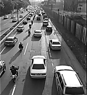 A picture that shows the practice of motorcycle lane-sharing.