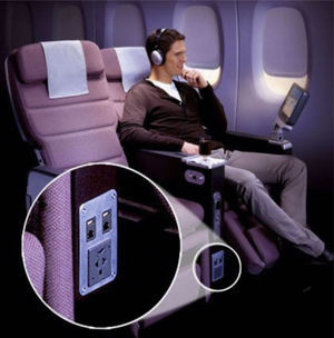 Ubicación de tomas de corriente en asientos de primera clase en un avión. Es importante llevar adaptadores internacionales para enchufes y así evitar incompatibilidades de clavijas.