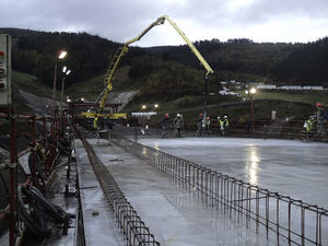 Casting the top slab with concrete pumped from the forward end of the preceding phase.