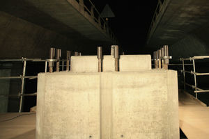 Cabeza superior de la fracción de pila construida in situ. Pueden verse barras salientes verticales de 50mm de diámetro en situación previa a la operación de montaje de la pieza superior prefabricada. En las barras de esquina se han colocado tuercas de compresión y placas de apoyo por debajo de los manguitos de empalme. En el resto de las barras solamente se han colocado manguitos de empalme.