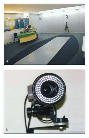 Laboratorio de marcha a: Laboratorio de análisis de marcha y movimiento. Nótese las plataformas de fuerza empotradas en el piso y cámaras infrarojas ancladas a la pared. b: Cámara infraroja con celdillas fotoeléctricas en la periferia y lente de captura central.