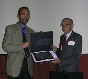 El entonces presidente de la AEM, José Pontón, entrega una placa a Manuel Pereiro Miguens durante el homenaje que le rindió la AEM en el año 2002.