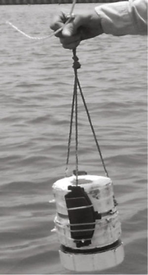 El transceptor submarino con pesos sujetos a la carcasa mediante cinchos a fin de hundirlo en el agua y realizar pruebas de campo. El transceptor de rastreo tiene la misma forma