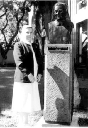 Sor María Suarez Váquez frente al busto de la madre Cerisola, ambas directoras de enfermería del Instituto Nacional de Cardiología Ignacio Chávez.