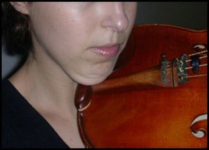 Interposição do violino entre o corpo da mandíbula e o ombro.