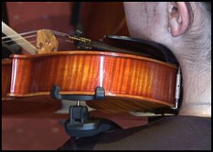 Interposição do violino entre o corpo da mandíbula e o ombro.