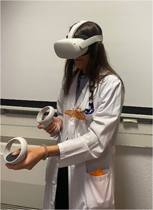 Resident doctor with the Oculus Meta Quest 2 VR glasses used to experiment with our technological application. The glasses have 2 joysticks for accessing the different options of the technological application.