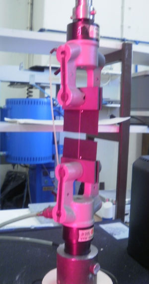 Specimen clamped with pneumatic grips and illuminated by the video extensometer, during a tensile test, where the yarn deformation is already meaningful.